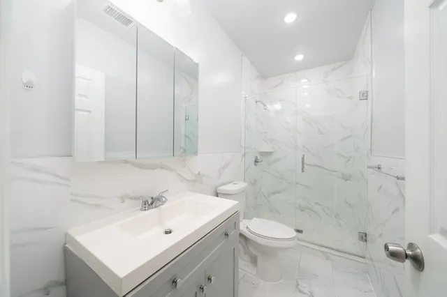 a bathroom with a sink a toilet and shower