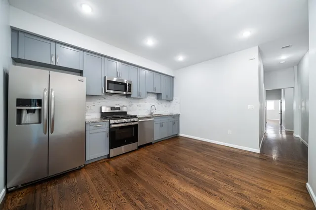 a kitchen with stainless steel appliances a refrigerator and a stove top oven