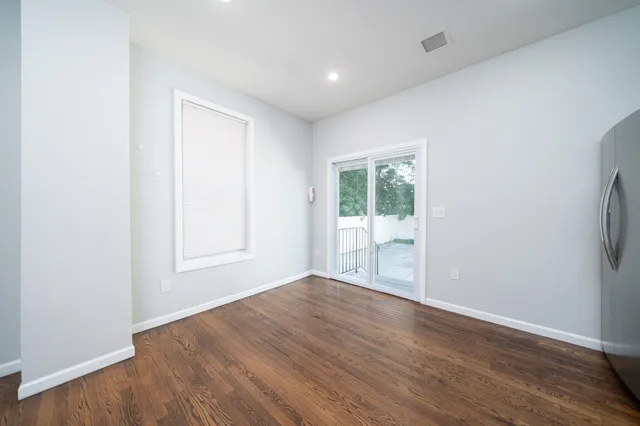 an empty room with wooden floor and a window