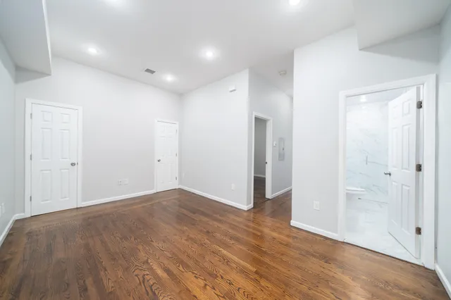 a view of an empty room with wooden floor