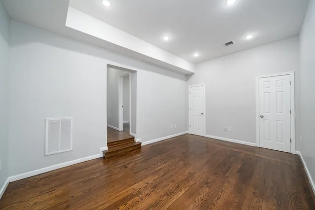 an empty room with wooden floor and white walls