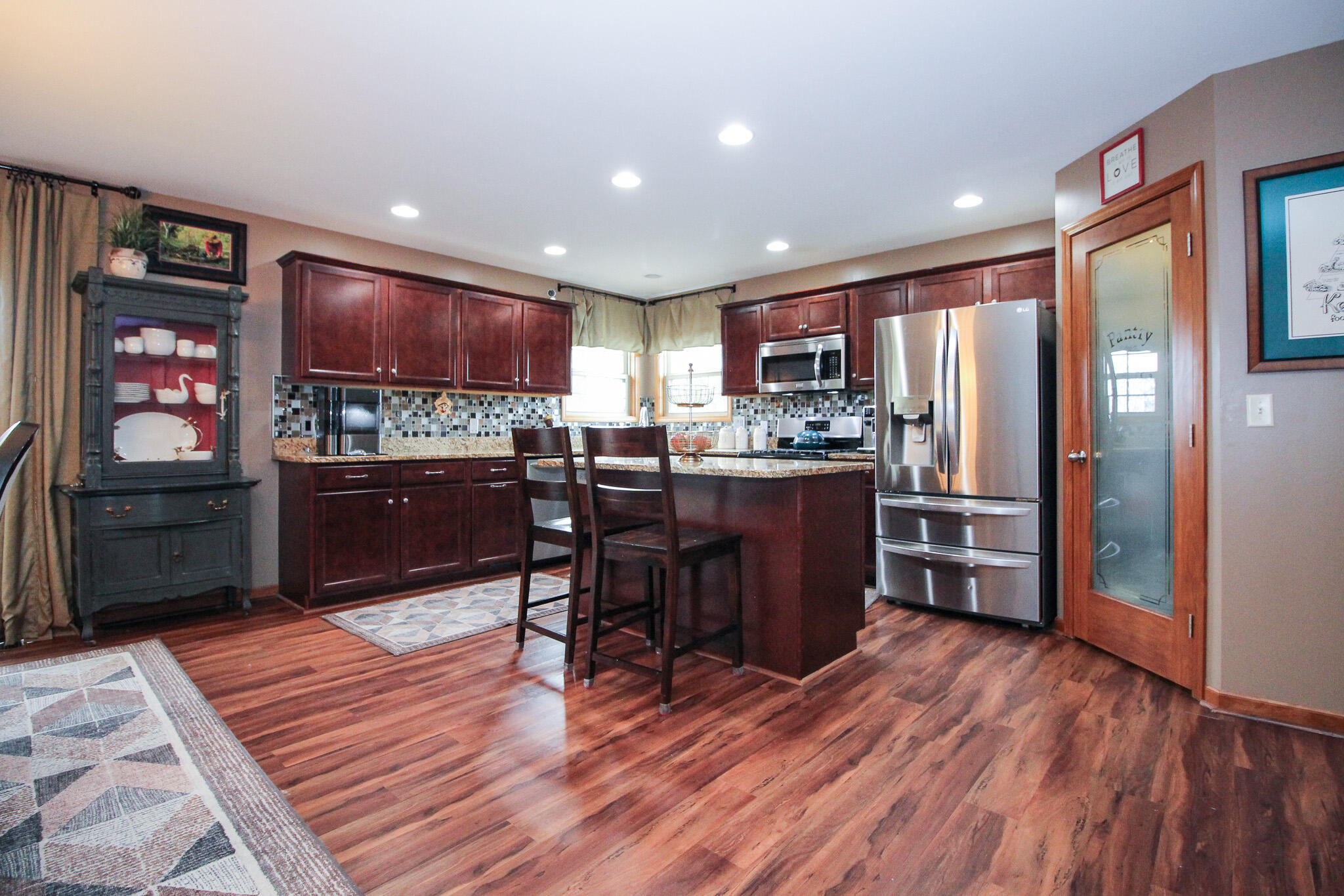 2913 Cardinal Drive Wheatfield, IN 46392 - Photo 10 of 34 a kitchen with stainless steel appliances kitchen island granite countertop wooden floors and wooden cabinets