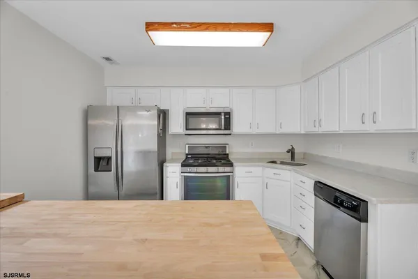 a kitchen with granite countertop stainless steel appliances and wooden cabinets
