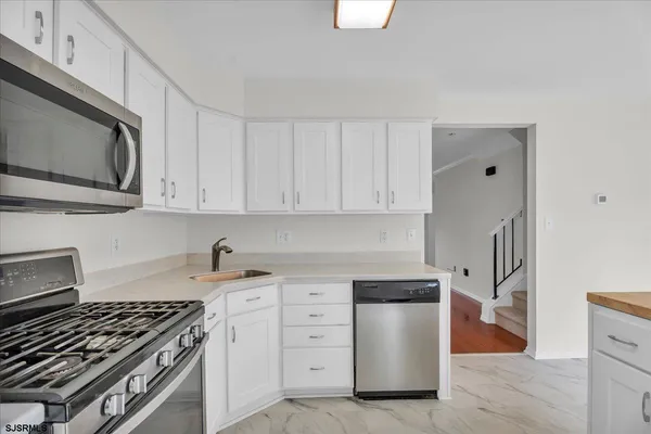 a kitchen with white cabinets and stainless steel appliances
