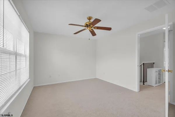 a view of a room with a ceiling fan and window