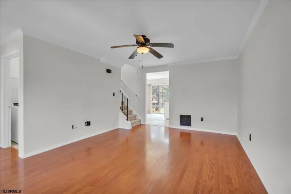 a view of empty room with wooden floor