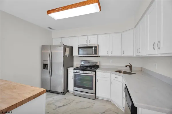 a kitchen with white cabinets and stainless steel appliances
