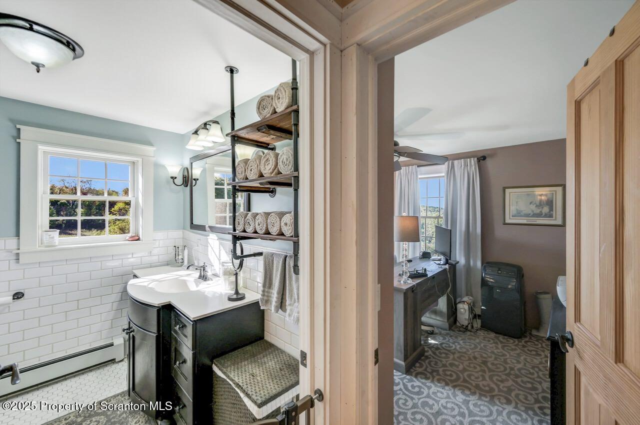 2225 Cherry Hill Road Clarks Summit, PA 18411 - Photo 38 of 81 a bathroom with a sink a mirror and a window