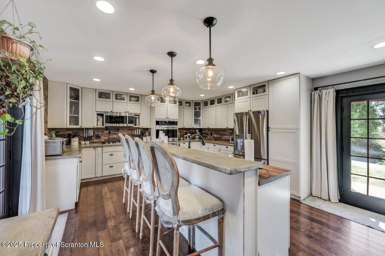 2225 Cherry Hill Road Clarks Summit, PA 18411 - Photo 10 of 81 a kitchen with stainless steel appliances kitchen island granite countertop a refrigerator a oven a sink dishwasher and a dining table with wooden floor