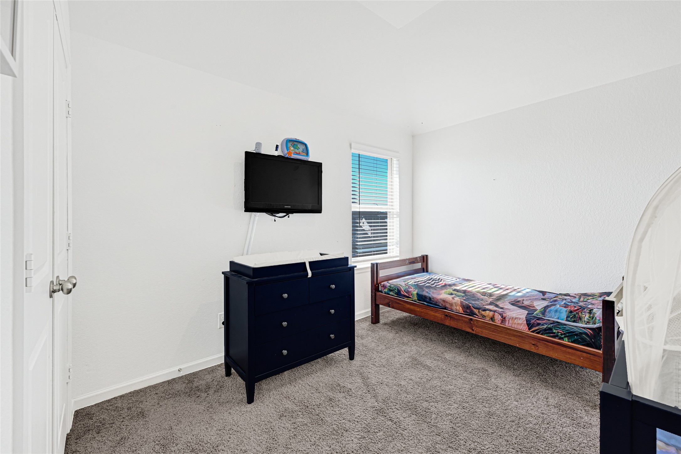 4307 Annandale Lane Rosharon, TX 77583 - Photo 16 of 31 This photo shows a bright bedroom also on the second floor, with white walls and carpeted flooring. A window allows natural light to fill the space, creating a welcoming atmosphere.