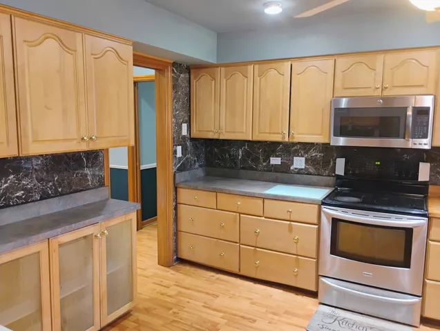 a kitchen with stainless steel appliances granite countertop a stove a sink and white cabinets