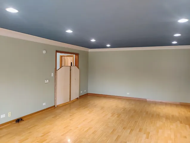 an empty room with wooden floor and natural light