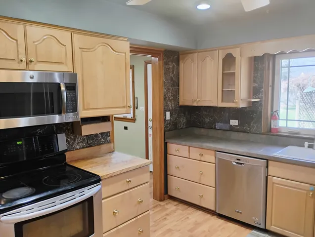 a kitchen with granite countertop white cabinets and black appliances