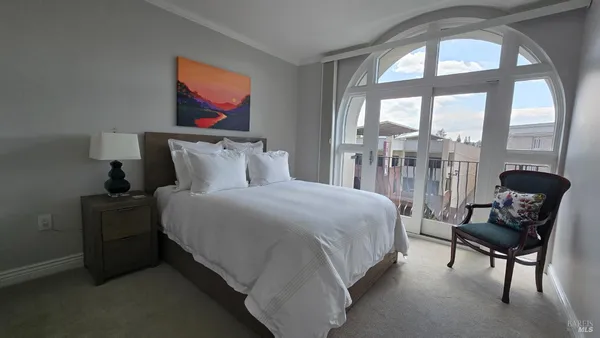 a bedroom with a bed and a painting on the wall
