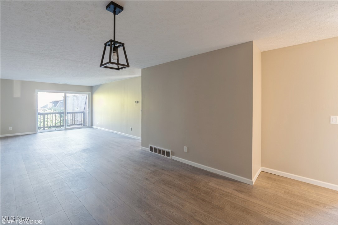 3725 Mayfield Road Cleveland Heights, OH 44121 - Photo 4 of 16 Unfurnished room with wood-type flooring and a textured ceiling