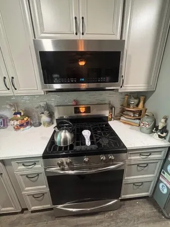 a stove top oven sitting inside of a kitchen