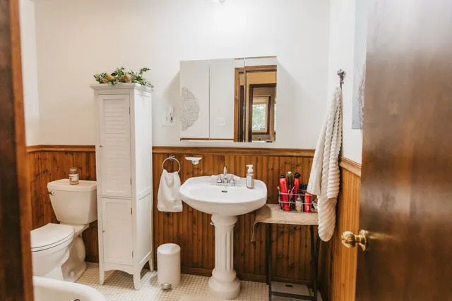 a bathroom with a sink mirror and toilet
