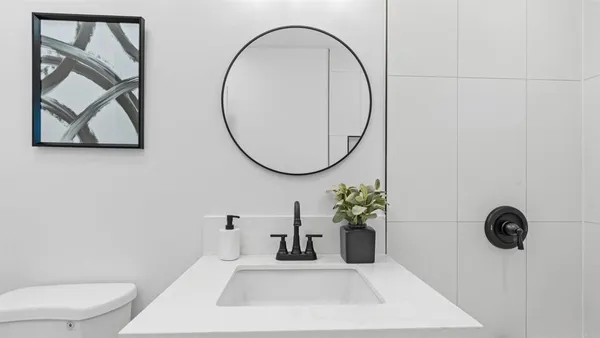 a bathroom with a sink a toilet and a mirror