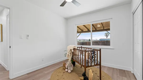an empty room with a window and wooden floor