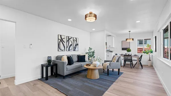 a living room with furniture wooden floor and a window