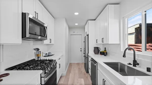a kitchen with stainless steel appliances a sink stove and cabinets