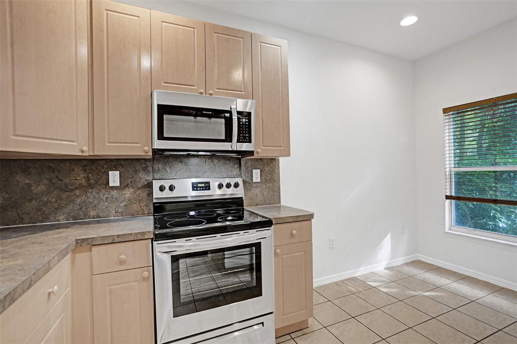 3533 Merrick Lane Margate, FL 33063 - Photo 4 of 27 a kitchen with granite countertop white cabinets stainless steel appliances and window