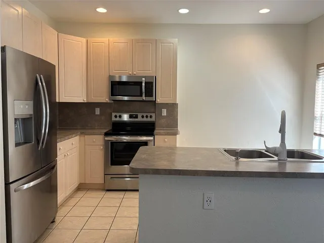 a kitchen with kitchen island a sink stainless steel appliances and cabinets