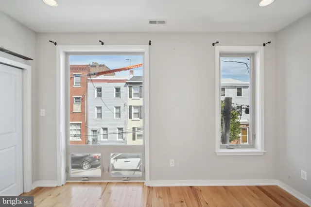 a view of a bedroom with wooden floor and windows