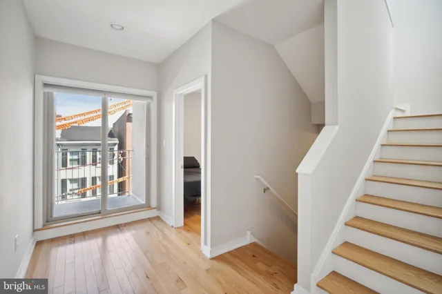 a view of a hallway with wooden floor and entryway
