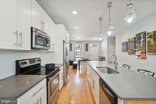 a kitchen with stainless steel appliances granite countertop a sink a stove oven a counter space and cabinets