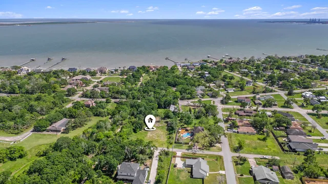 an aerial view of a residential houses with street and trees