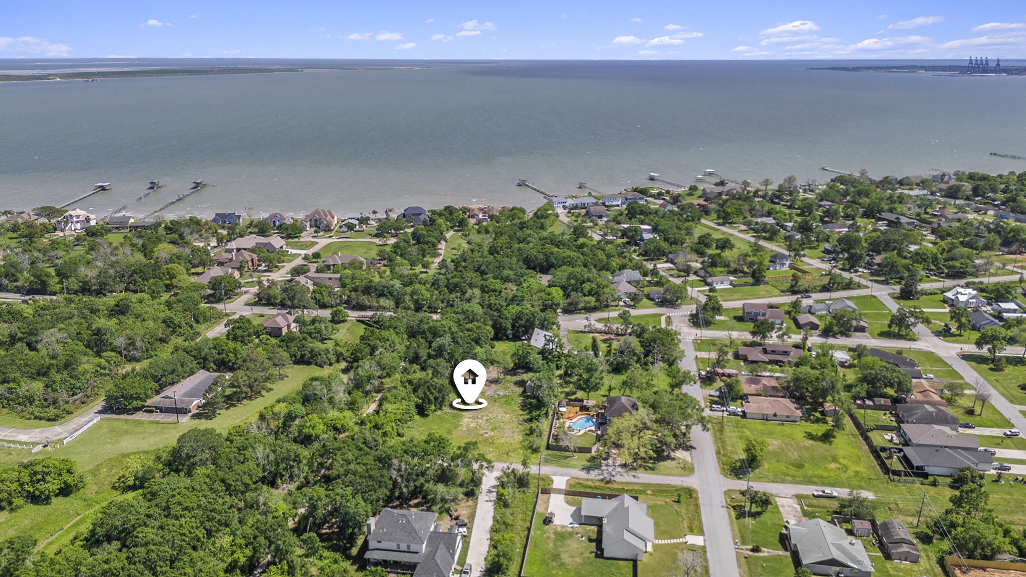 an aerial view of a residential houses with street and trees