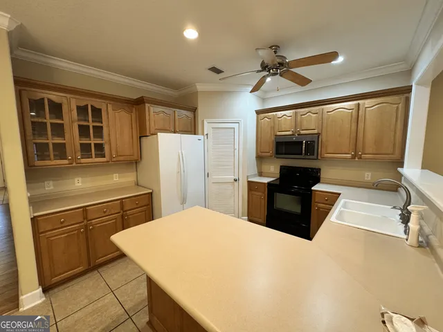 a kitchen with a refrigerator a stove a sink dishwasher and a oven with wooden floor