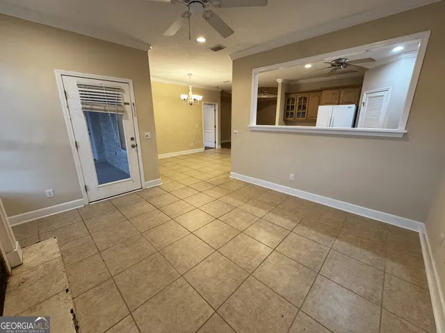a view of a hallway with wooden floor and a bathroom