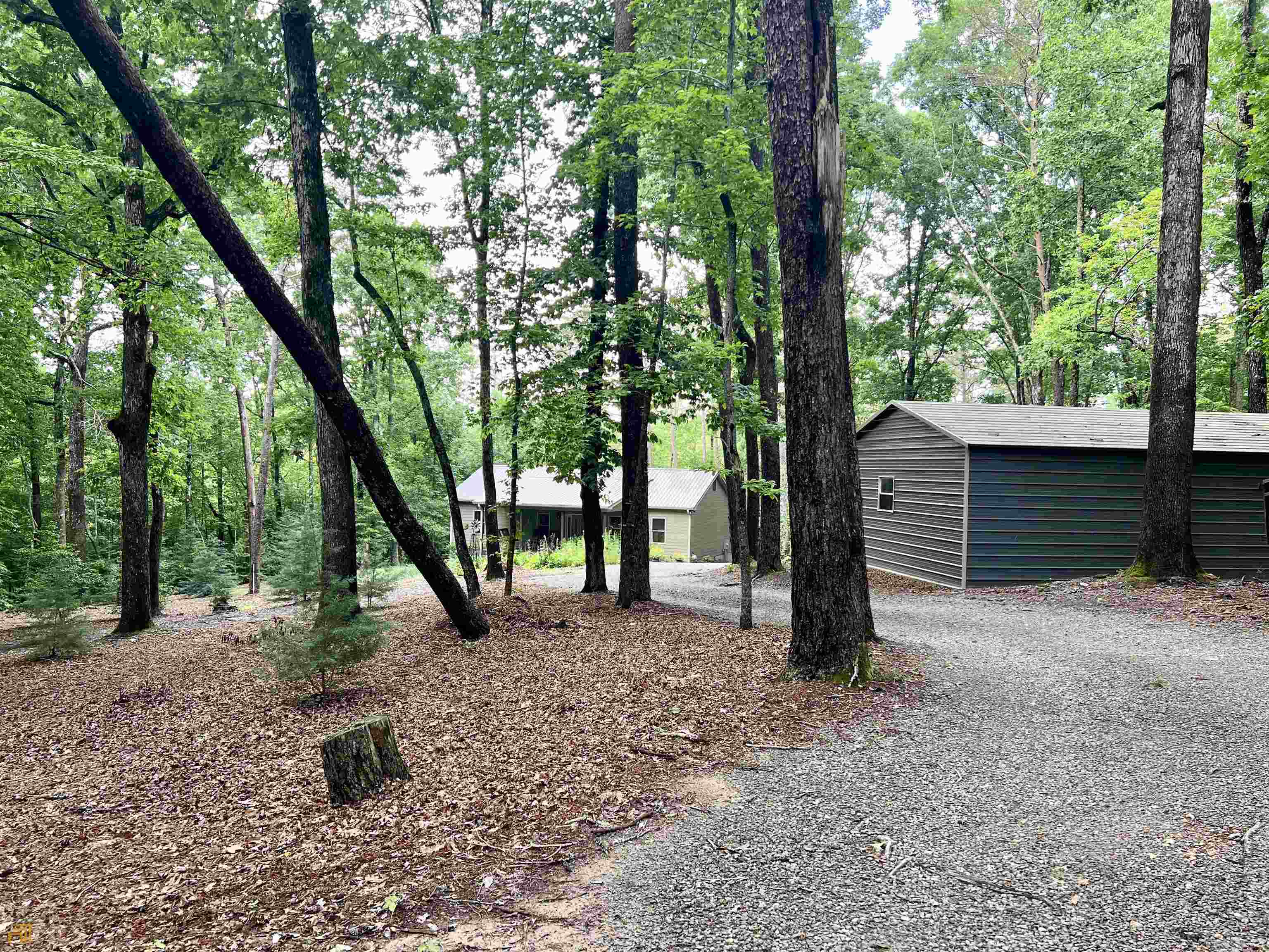 186 Holly Lane Cleveland, GA 30528 - Photo 51 of 58 a view of a backyard with large trees and a small barn