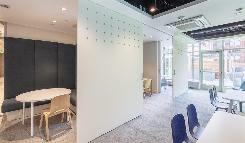 50 Rogers Street, Unit 415 Cambridge, MA 02142 - Photo 13 of 15 a living room with furniture a large window and chairs