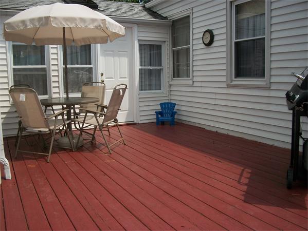398 Plumtree Road Springfield, MA 01118 - Photo 22 of 24 a view of a roof deck with table and chairs under an umbrella with wooden floor