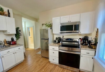 207 Princeton Street, Unit 2 Boston, MA 02128 - Photo 1 of 12 a kitchen with cabinets stainless steel appliances and wooden floor