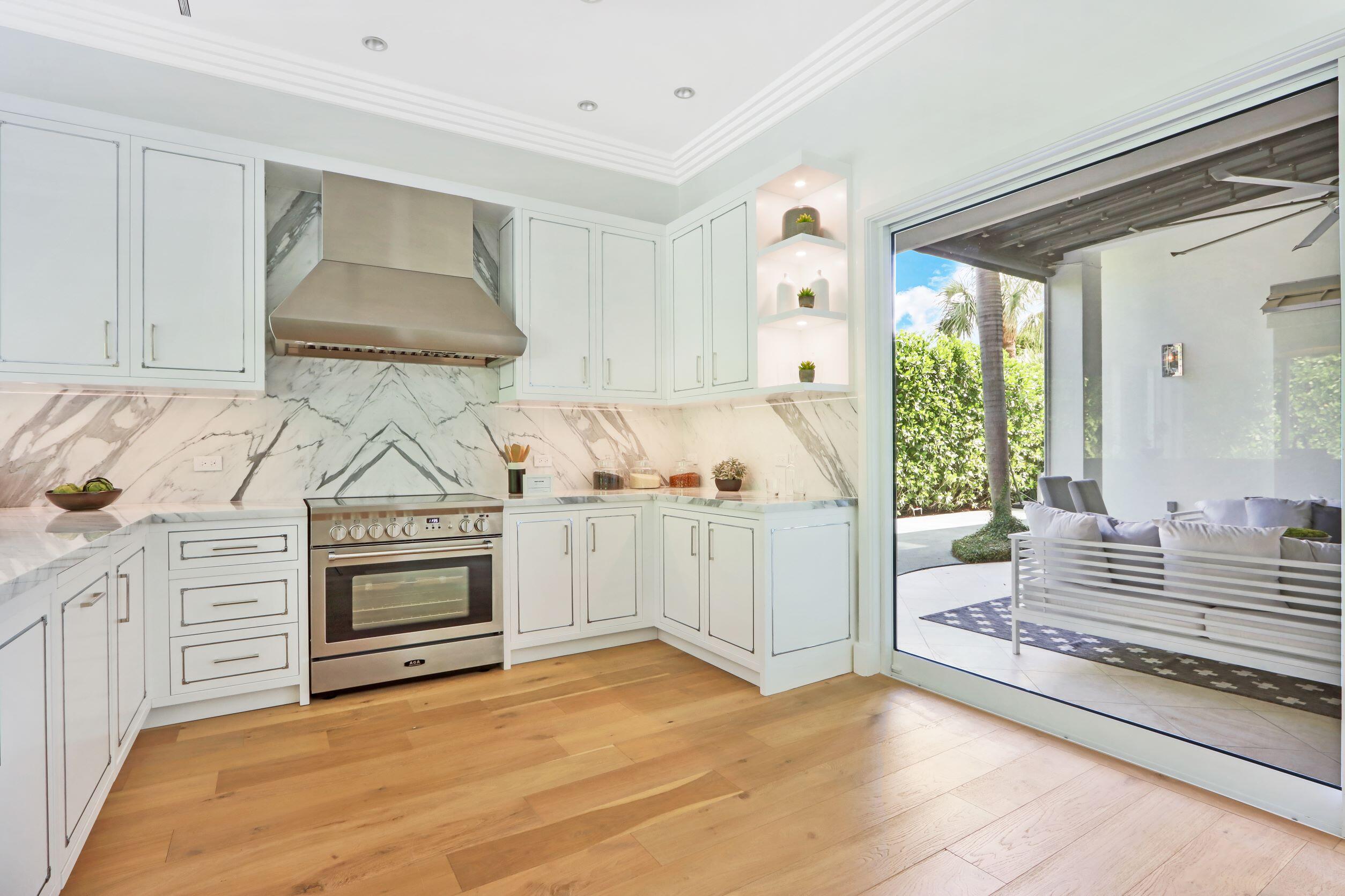 215 Indian Road Palm Beach, FL 33480 - Photo 7 of 33 a kitchen with white cabinets and white appliances