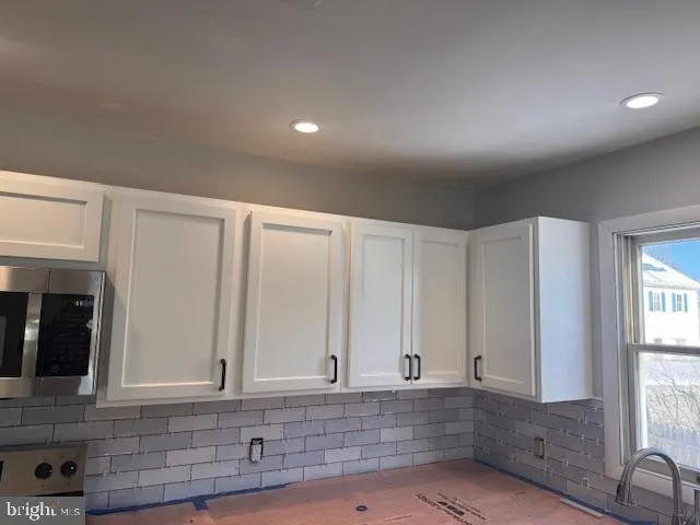 a kitchen with kitchen island granite countertop stainless steel appliances and cabinets