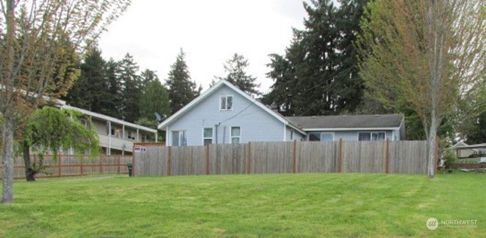 a view of a house with a yard and a wooden deck