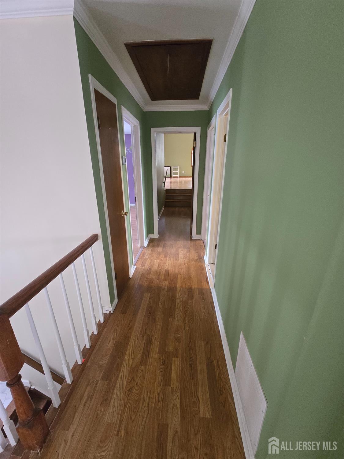 241 Monmouth Road Freehold, NJ 07728 - Photo 11 of 30 a view of a hallway to a livingroom with wooden floor and stairs