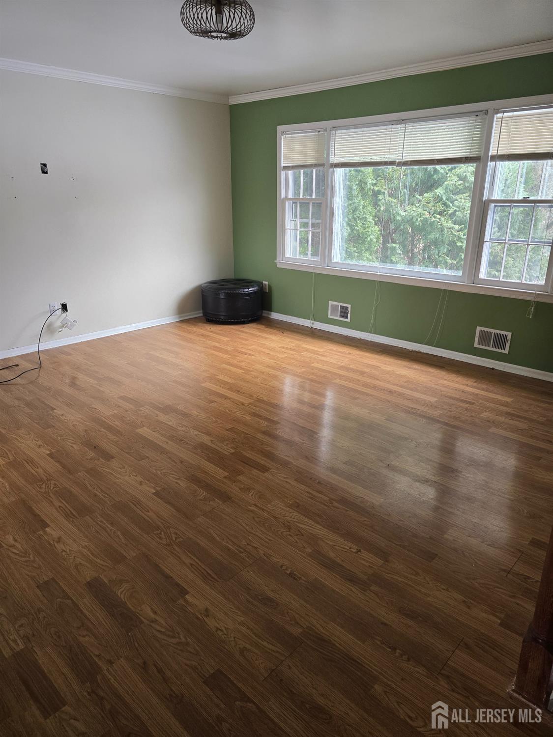 241 Monmouth Road Freehold, NJ 07728 - Photo 6 of 30 a view of an empty room with wooden floor and a window