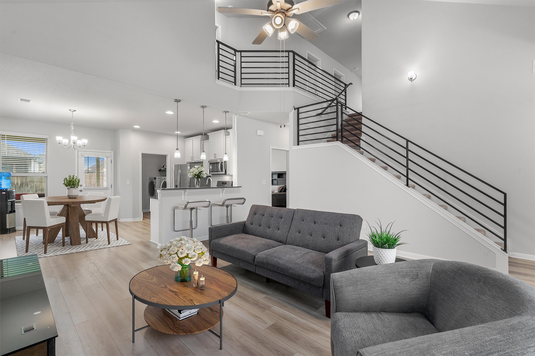 224 Backstays Loop Kyle, TX 78640 - Photo 3 of 19 Open-concept living space featuring wood-finish flooring and a contemporary staircase with black horizontal railings