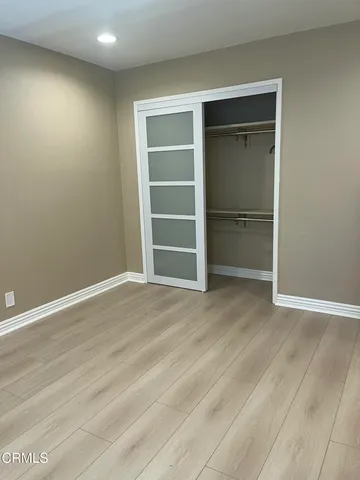 a view of an empty room with a closet and a window