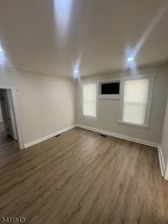 an empty room with wooden floor and window