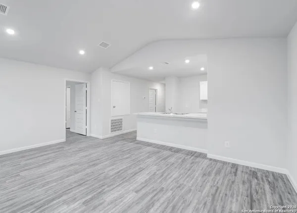 a view of an empty room with wooden floor