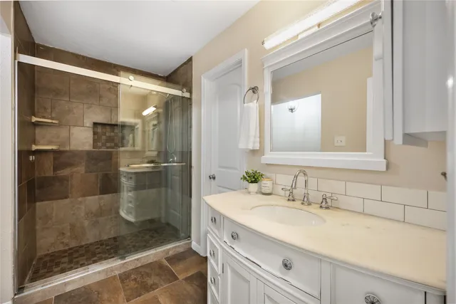 a bathroom with a shower sink and mirror