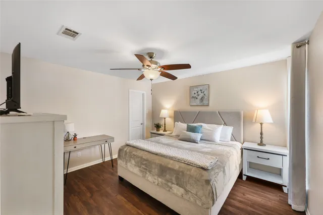 a bedroom with a bed and a flat tv screen on dresser