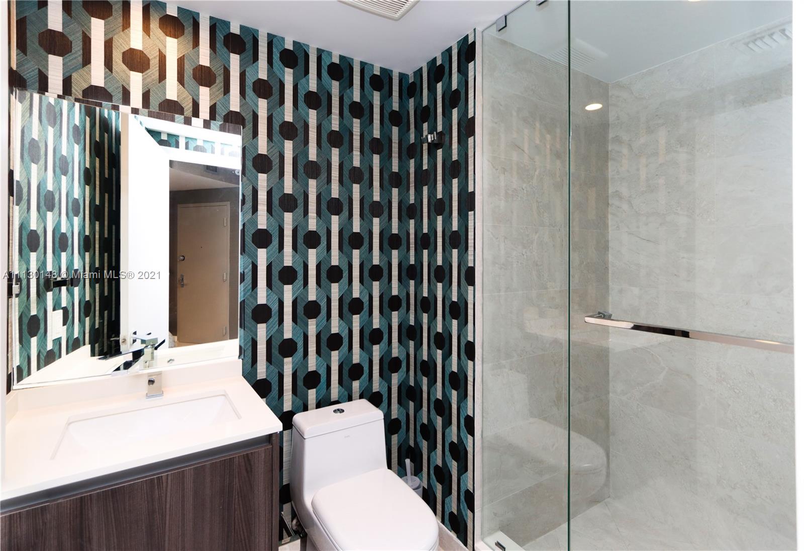 Edgewater Miami, FL 33132 - Photo 6 of 13 a bathroom with a sink a toilet a mirror and shower